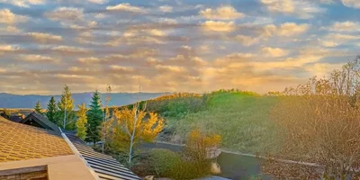 Sunrise view over Park City homes with autumn trees and mountain backdrop, ideal setting for off-market properties.