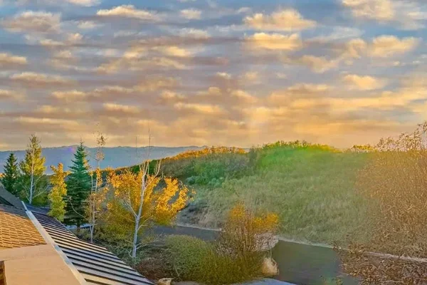 Sunrise view over Park City homes with autumn trees and mountain backdrop, ideal setting for off-market properties.