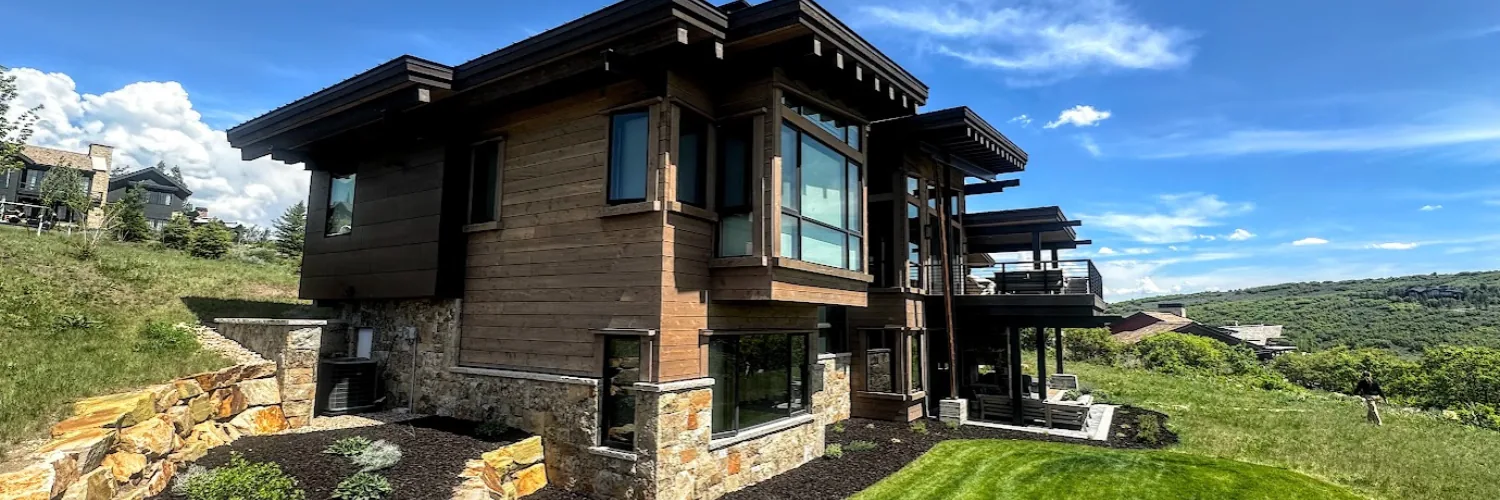 Contemporary mountain home in Park City, Utah with modern architecture, large glass windows, and panoramic alpine views — represented by Derrik Carlson, Park City Realtor.