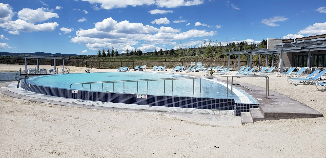 Resort-style swimming pool at Promontory Club in Park City with lounge chairs and mountain backdrop
