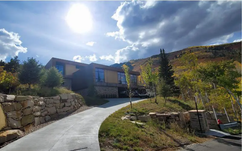 Single-family home in Aspen Springs Ranch, Thaynes Canyon, Park City, Utah, with stone retaining walls, curved driveway, and fall mountain foliage