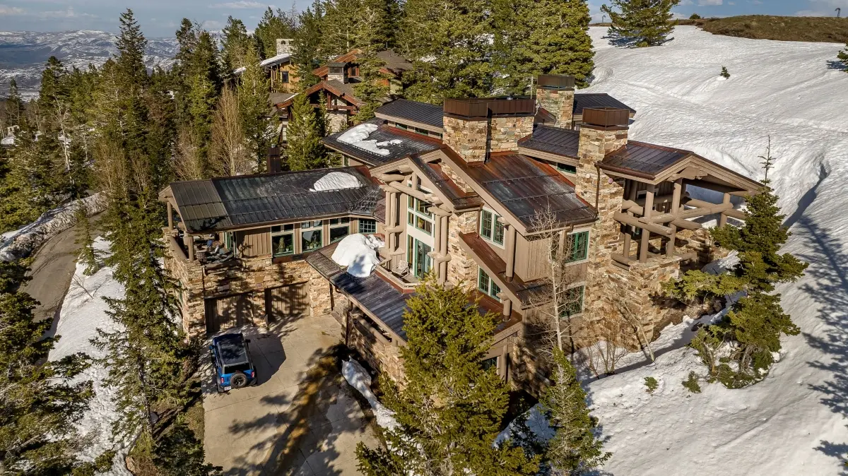 Aerial view of a luxury mountain home in Deer Valley with ski run access and snow-covered slopes in Park City, Utah