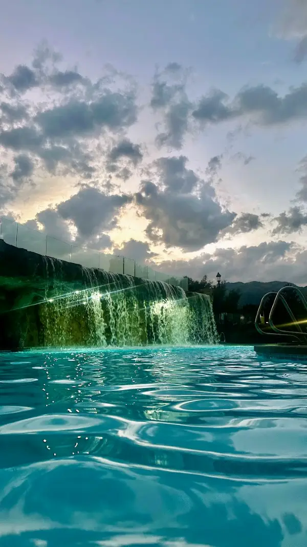 Outdoor waterfall pool at Homestead Residences in Midway, Utah with surrounding mountains and resort amenities.