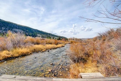 Weber River flowing through Oakley Utah with mountain views and open brushland in early fall