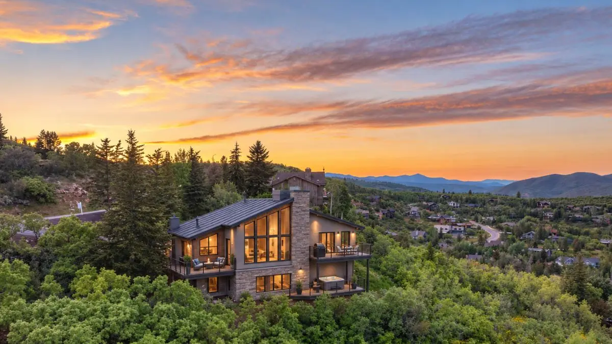 Contemporary home set among trees in Pinebrook, Snyderville Basin, Park City, UT 84098, at sunset