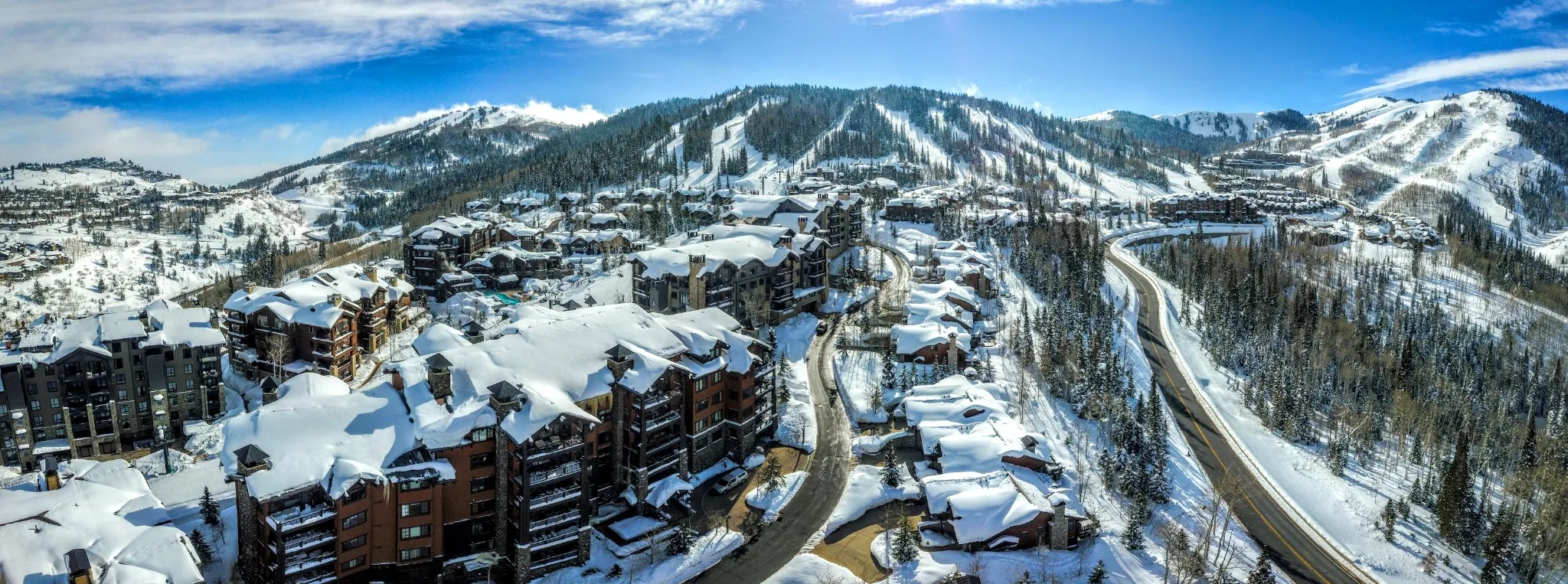 Ski-in-ski-out luxury condos and homes at Deer Valley Resort with snow-covered rooftops and scenic mountain views on a clear winter day in Park City.