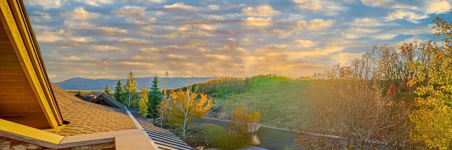 Sunrise view over Park City homes with autumn trees and mountain backdrop, ideal setting for off-market properties.